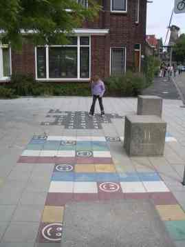 Child playing on pavement in residential area of Delft